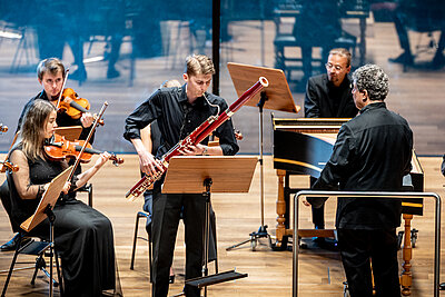 Orchester, Dirigent und Wettbewerbskandidat spielen live auf einer Konzertbühne