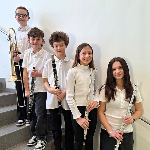 Die Ensemblemitglieder mit ihren Instrumenten aufgereiht in einem Stiegenaufgang