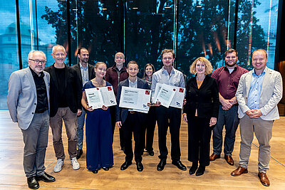 Jurymitglieder und Wettbewerbsgewinner*innen mit ihren Urkunden
