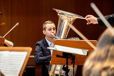 ein Teil des Orchester und der Wettbewerbskandidat spielen live auf einer Konzertbühne