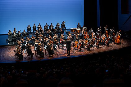Das Orchester spielt live auf der beleuchteten Konzertbühne