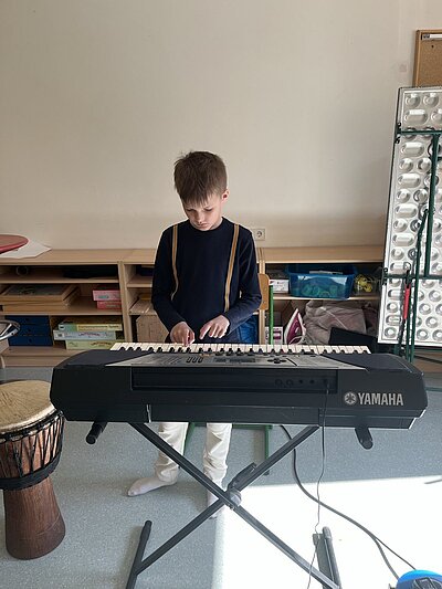 Ein Schüler spielt mit voller Konzentration ganz ohne Hilfe auf dem Keyboard