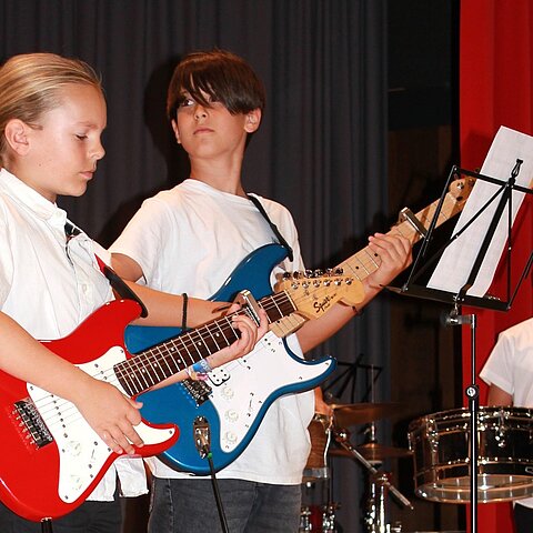 Zwei Jugendliche spielen gemeinsam E-Gitarre