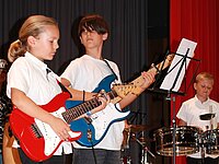 Zwei Jugendliche spielen gemeinsam E-Gitarre