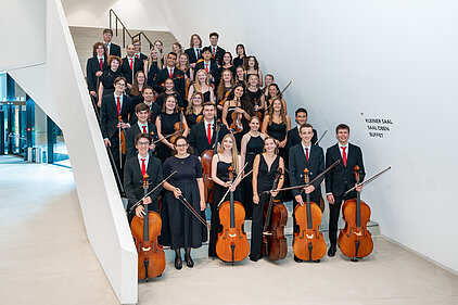 Ein Teil des Orchesters steht auf einer Treppe